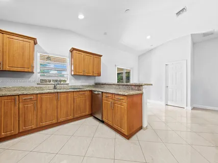 a kitchen with stainless steel appliances granite countertop a sink and cabinets