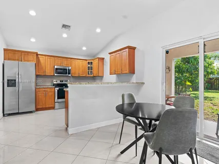 a kitchen with stainless steel appliances granite countertop a stove top oven a sink a refrigerator and a granite counter tops