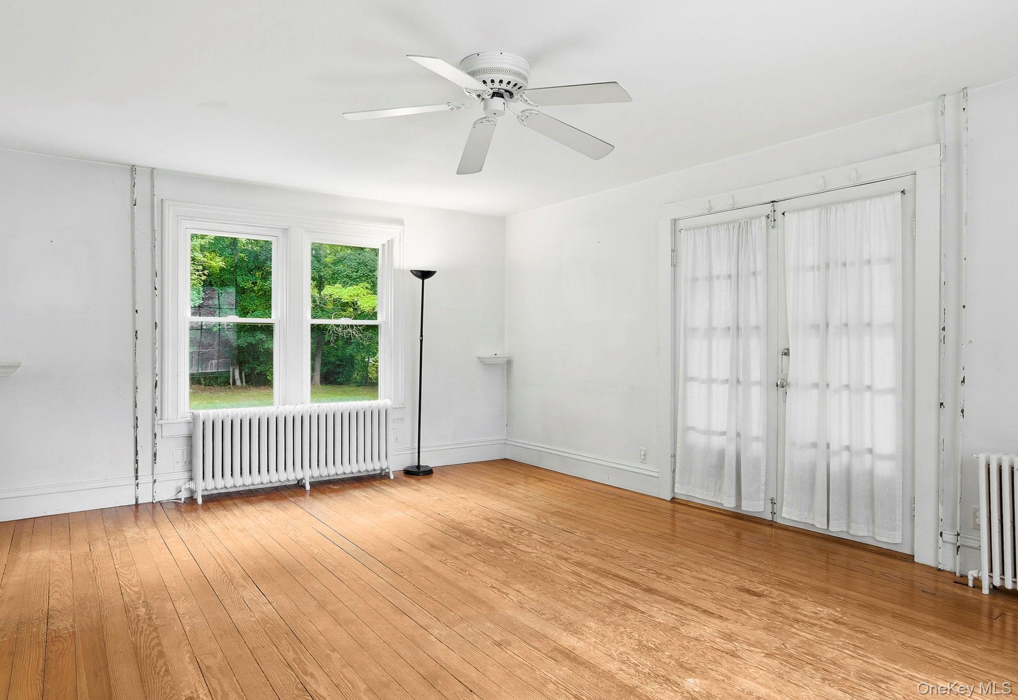 16 Hornbeck Road Poughkeepsie, NY 12603 - Photo 5 of 10 Hardwood flooring featuring a ceiling fan, dual windows, and white baseboards