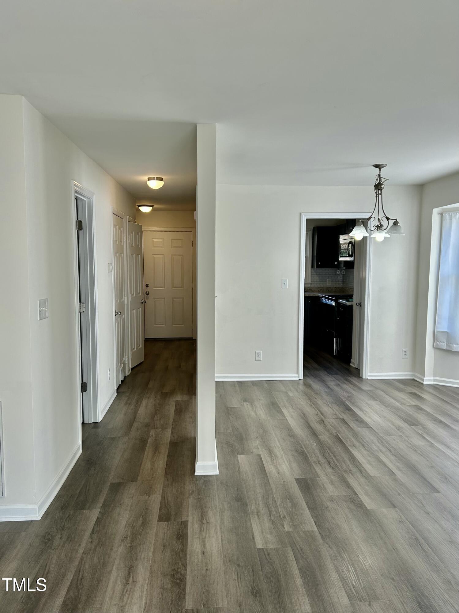 8107 Perry Creek Raleigh, NC 27616 - Photo 3 of 10 a view of a big room with wooden floor and a kitchen