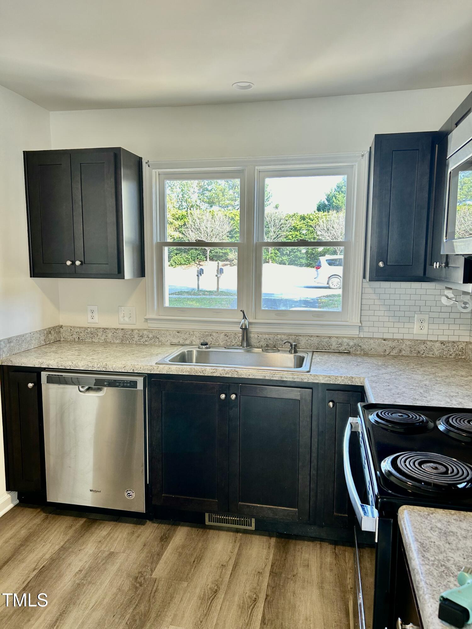 8107 Perry Creek Raleigh, NC 27616 - Photo 6 of 10 a kitchen with granite countertop wooden cabinets a sink and a stove