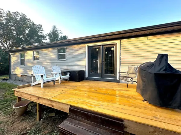 a view of a patio with table and chairs with wooden floor and fence