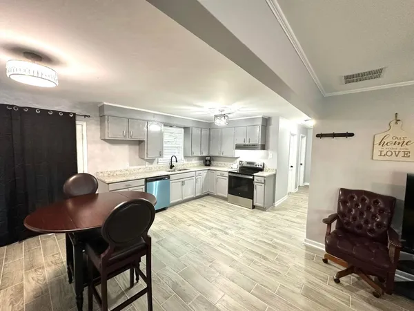 a kitchen with a refrigerator and chairs