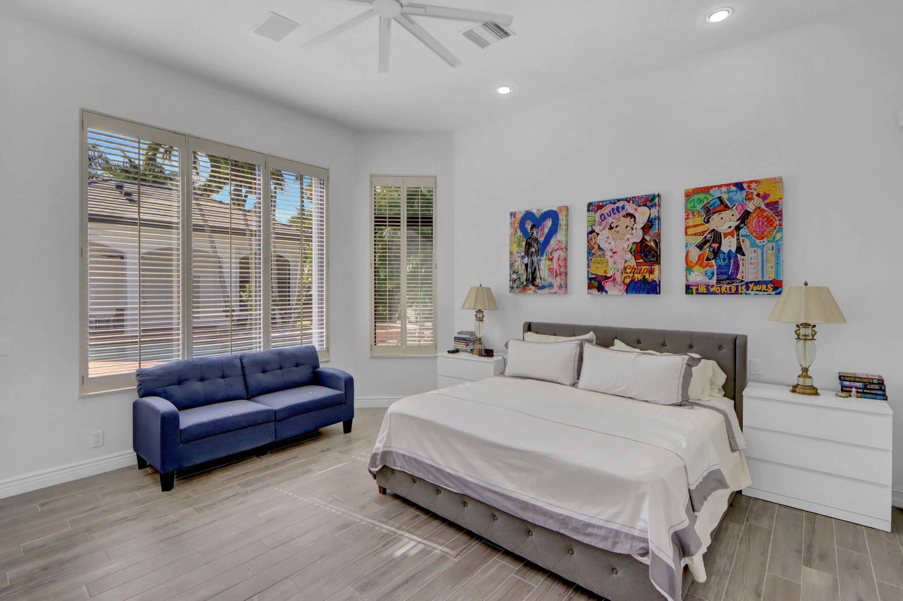 3799 Northwest Coventry Lane Boca Raton, FL 33496 - Photo 13 of 49 a spacious bedroom with a bed a couch and a large window