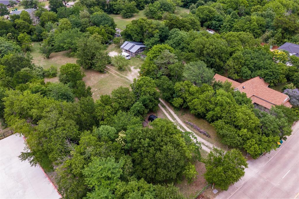 1007 West Belt Line Road Cedar Hill, TX 75104 - Photo 16 of 30 Expansive wooded property featuring a primary residence with a brown shingle roof, a secondary structure, and multiple dirt paths