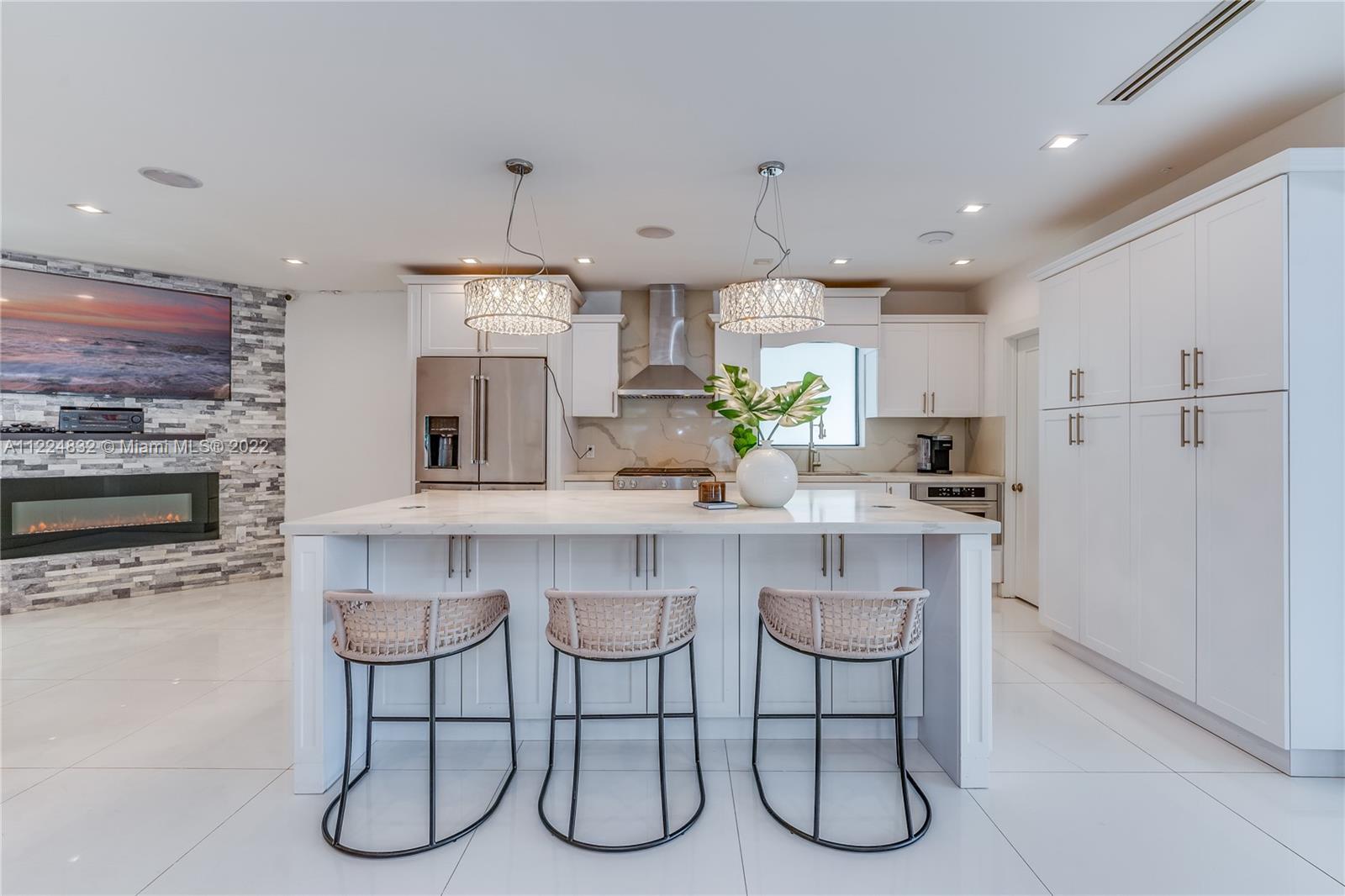 401 Southwest 23rd Road Miami, FL 33129 - Photo 13 of 25 a kitchen with stainless steel appliances a table chairs refrigerator and microwave
