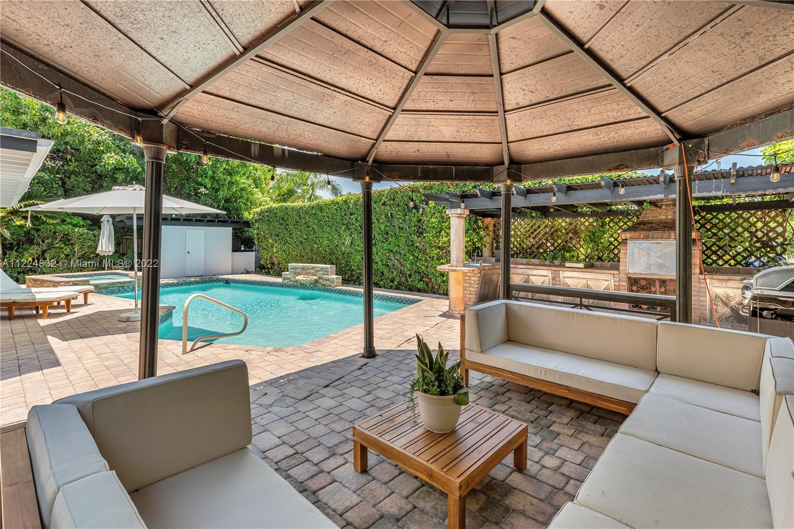 401 Southwest 23rd Road Miami, FL 33129 - Photo 24 of 25 a view of a patio with a table and chairs under an umbrella with a small yard