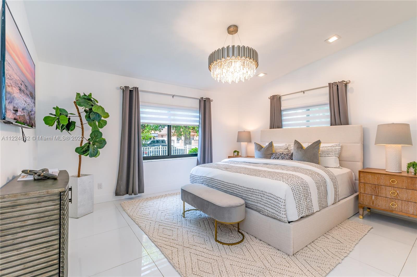 401 Southwest 23rd Road Miami, FL 33129 - Photo 9 of 25 a spacious bedroom with a bed and a chandelier