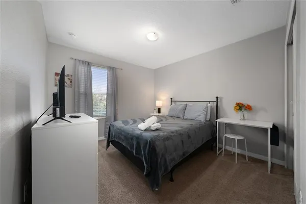 a bedroom with a bed and flat screen tv