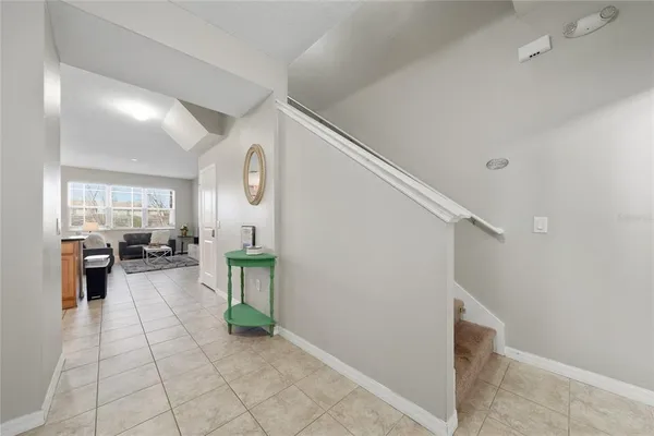 a view of a hallway with workspace and living room filled with furniture
