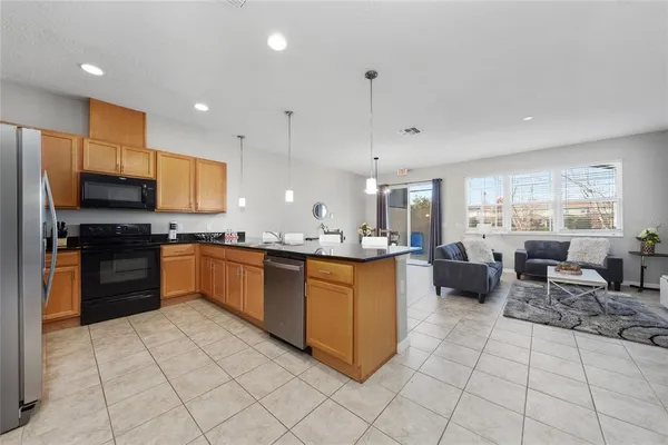a large kitchen with stainless steel appliances lots of counter top space cabinets and furniture