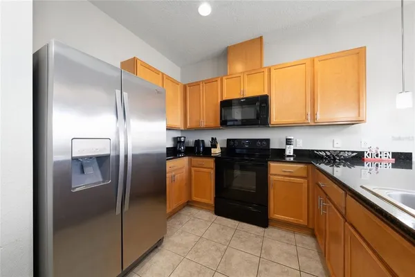 a kitchen with stainless steel appliances granite countertop a refrigerator a stove a sink dishwasher and a microwave