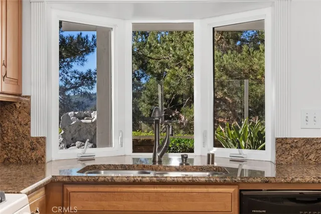 a bathroom with a granite countertop sink and next to a window