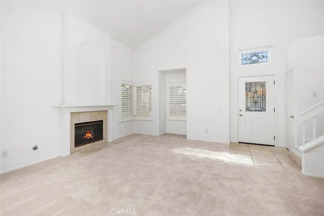 an empty room with windows and fireplace