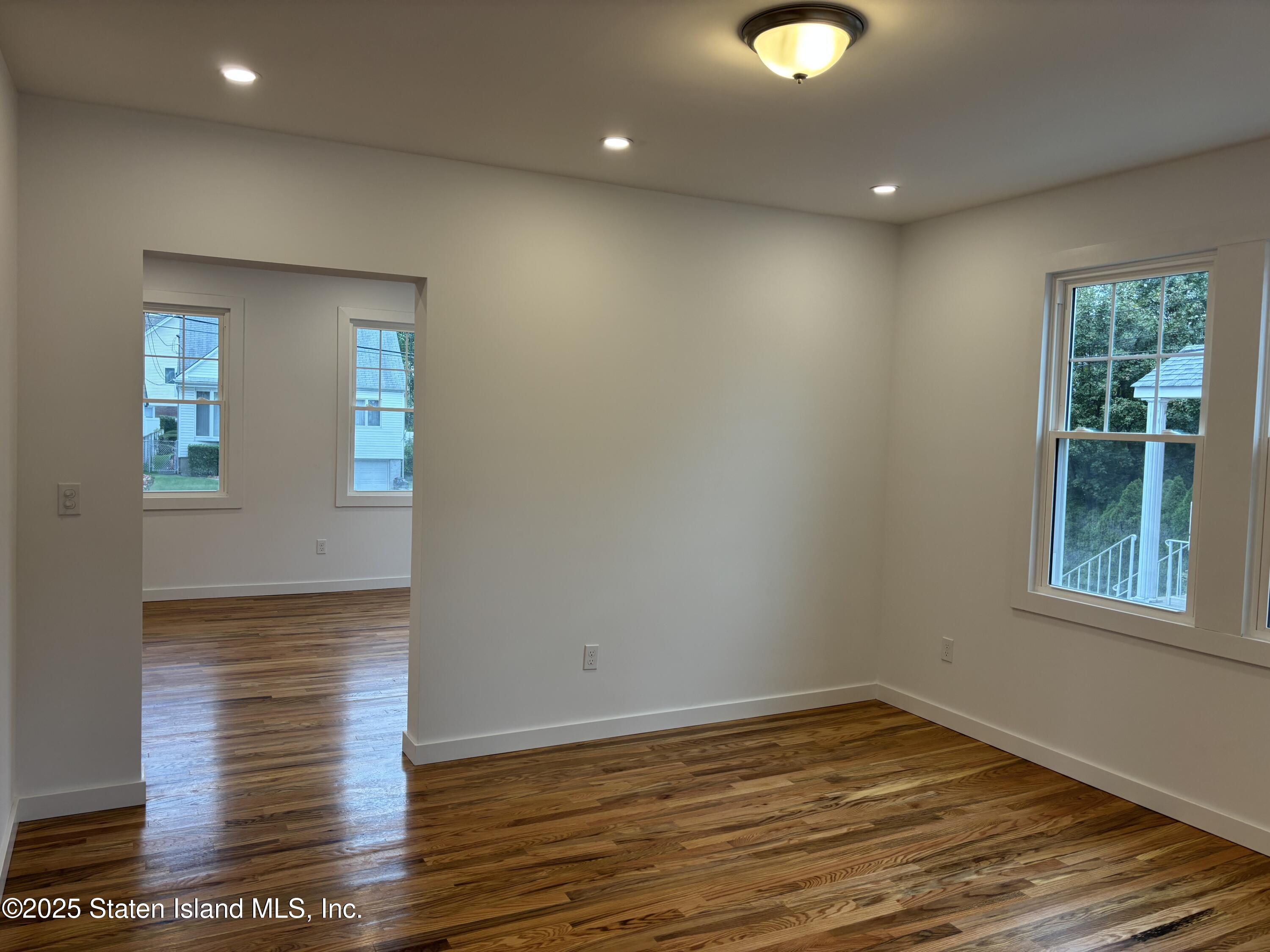 677 Bement Avenue Staten Island, NY 10310 - Photo 8 of 37 a view of an empty room with wooden floor and a window