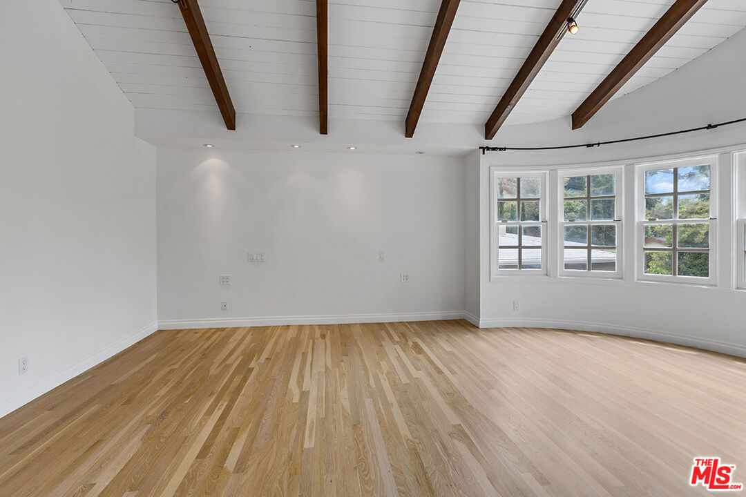 1462 Rising Glen Road Los Angeles, CA 90069 - Photo 23 of 40 a view of empty room with wooden floor and fan