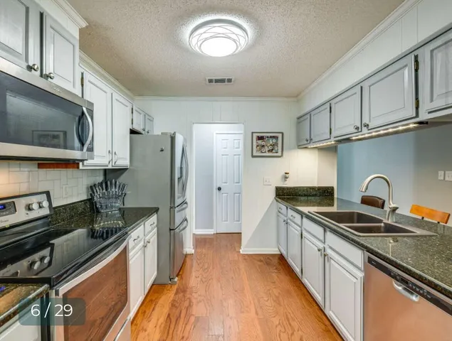 a kitchen with stainless steel appliances granite countertop a sink stove and refrigerator
