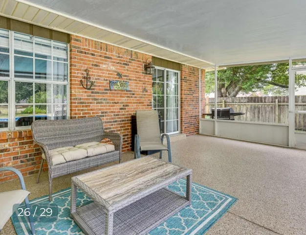 a living room with furniture a large window and wooden floor