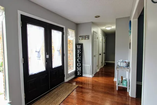 a view of hallway with livingroom and wooden floor