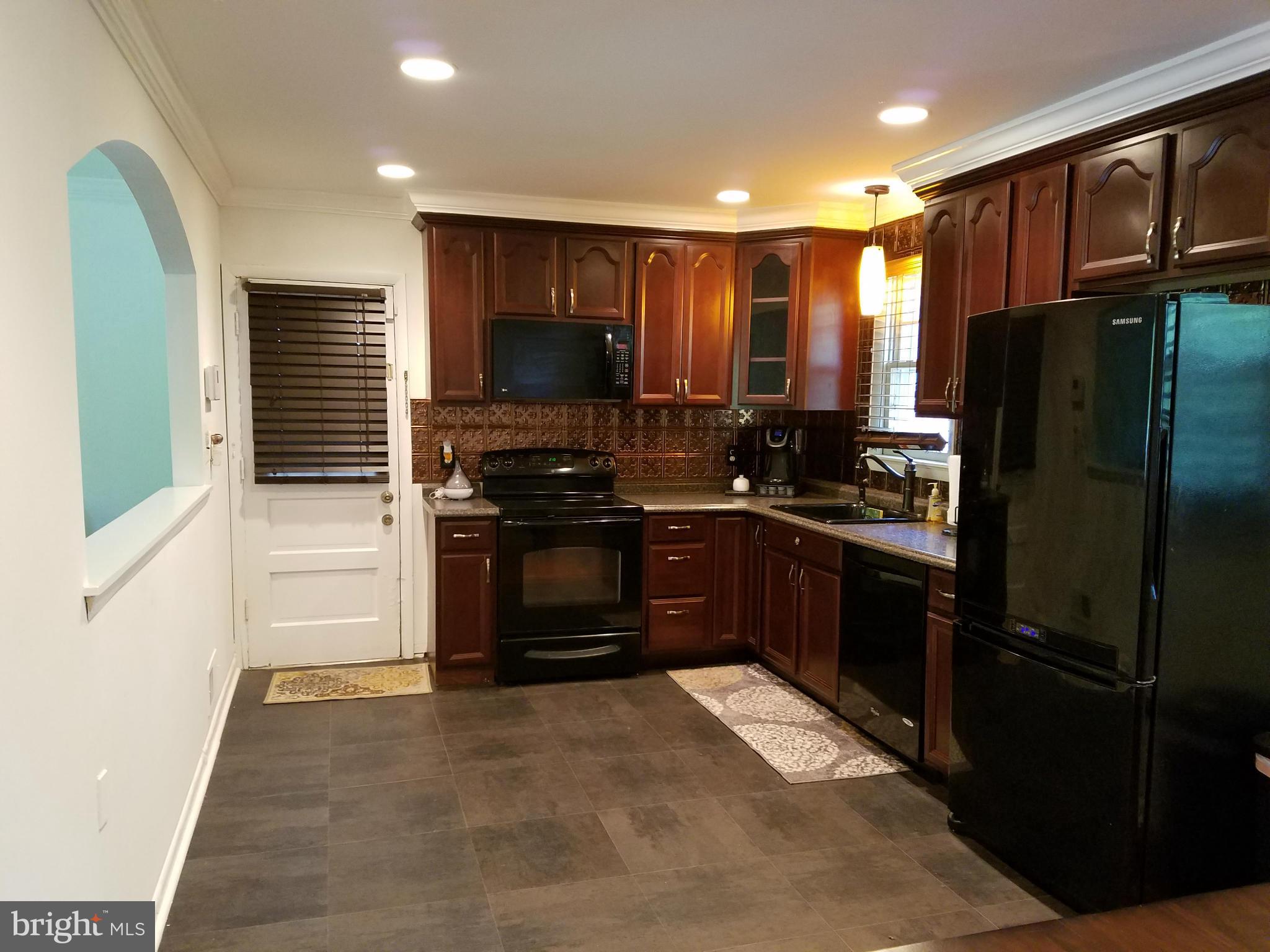 8506 Schultz Road Clinton, MD 20735 - Photo 6 of 30 a kitchen with granite countertop a refrigerator stove and microwave
