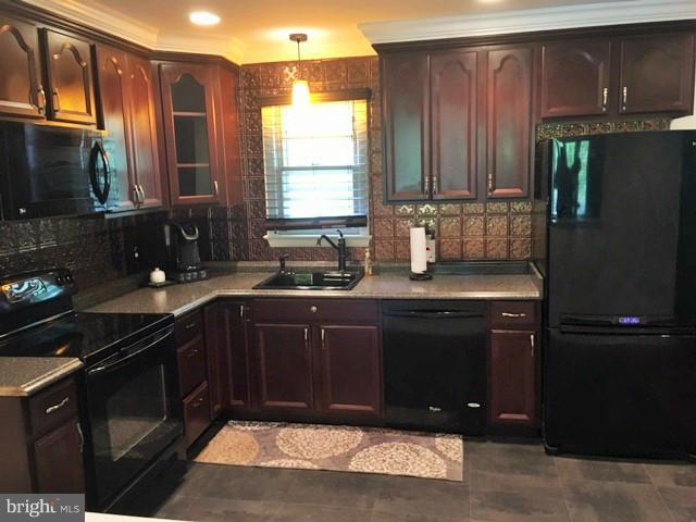 8506 Schultz Road Clinton, MD 20735 - Photo 7 of 30 a kitchen with granite countertop wooden cabinets and a sink