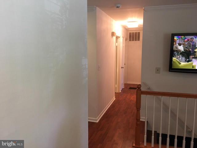 8506 Schultz Road Clinton, MD 20735 - Photo 9 of 30 a view of a hallway with wooden floor and a painting on the wall