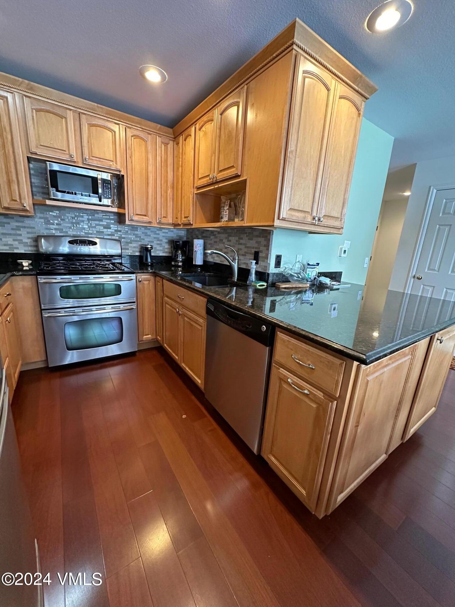 8 Red Tail Drive Edwards, CO 81632 - Photo 2 of 9 a kitchen with stainless steel appliances granite countertop a stove a sink dishwasher and a microwave