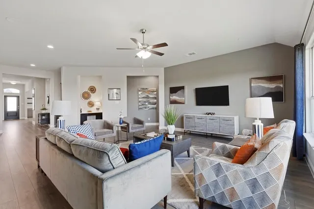 a living room with furniture flat screen tv and wooden floor
