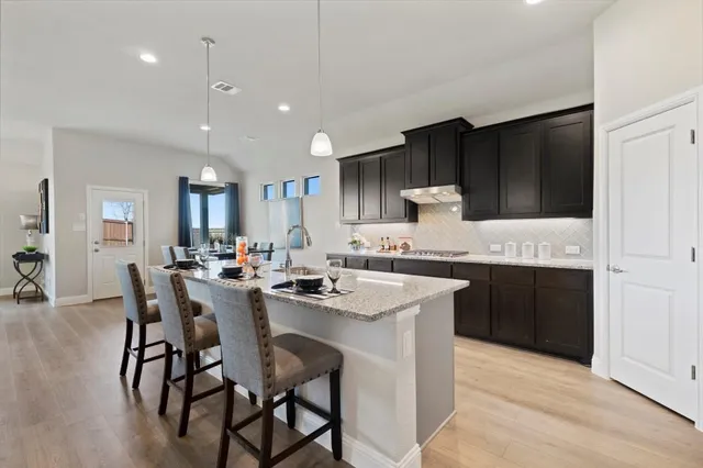 a kitchen with granite countertop a sink appliances and cabinets