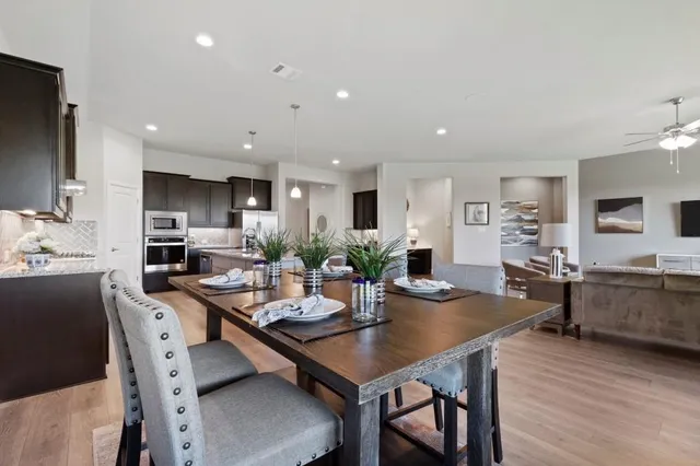 a kitchen with a dining table chairs and white appliances