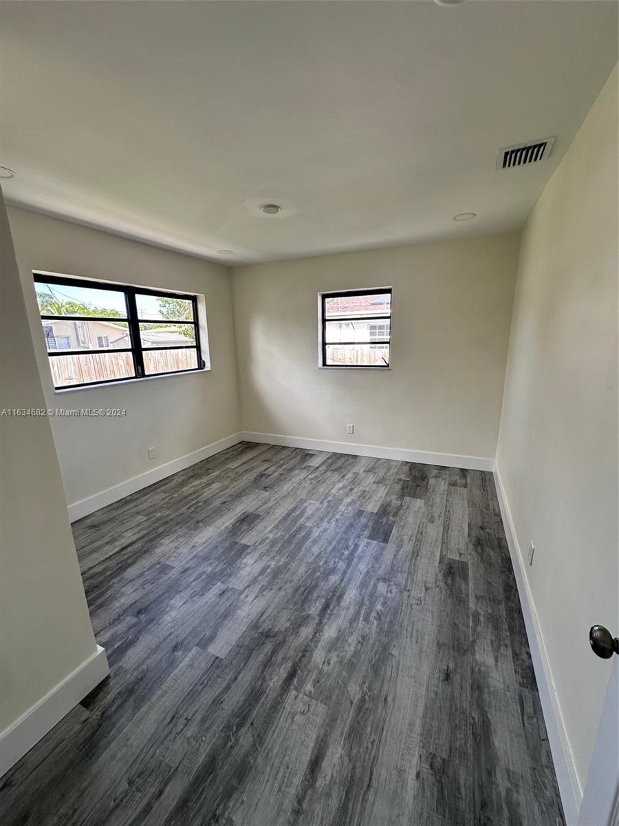 6517 Wiley Street Hollywood, FL 33023 - Photo 6 of 17 an empty room with wooden floor and windows
