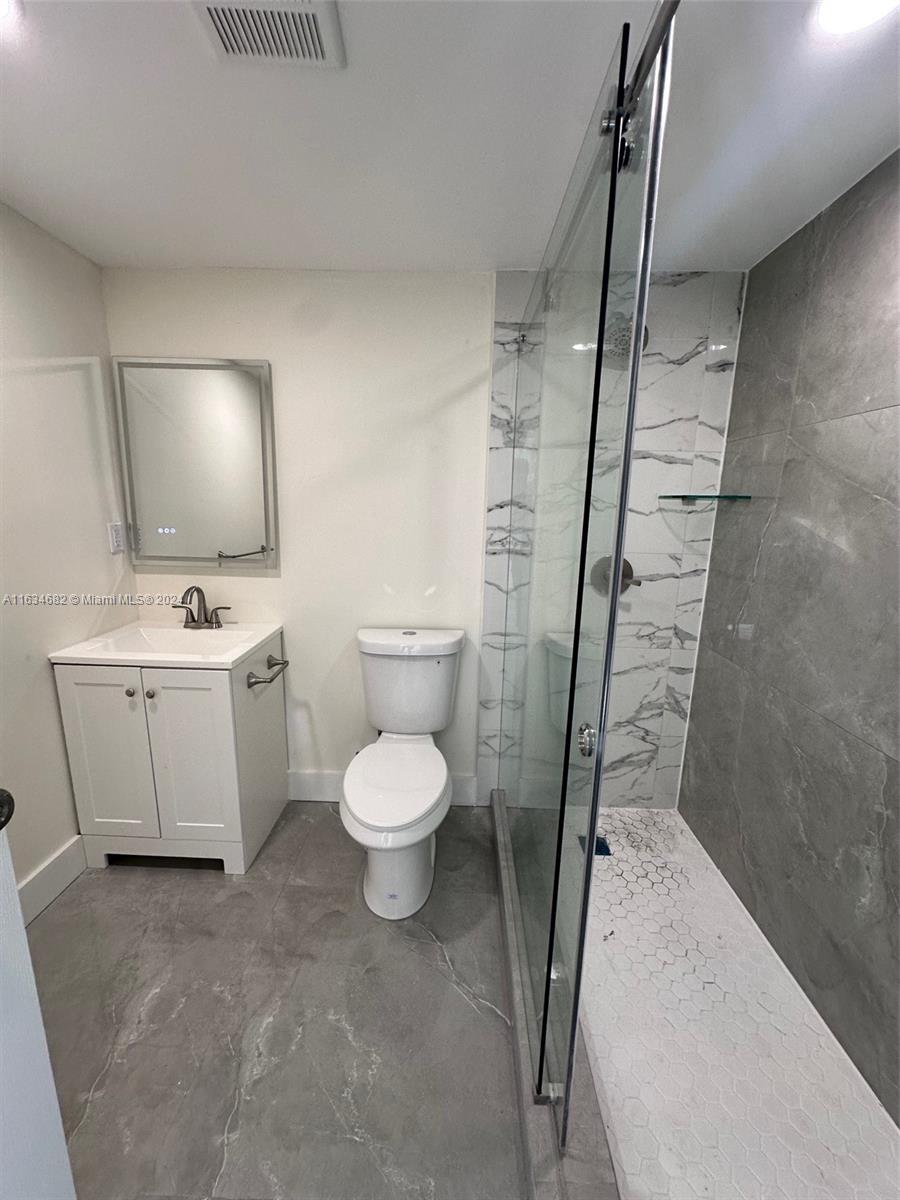 6517 Wiley Street Hollywood, FL 33023 - Photo 10 of 17 a white toilet sitting next to a bathroom sink