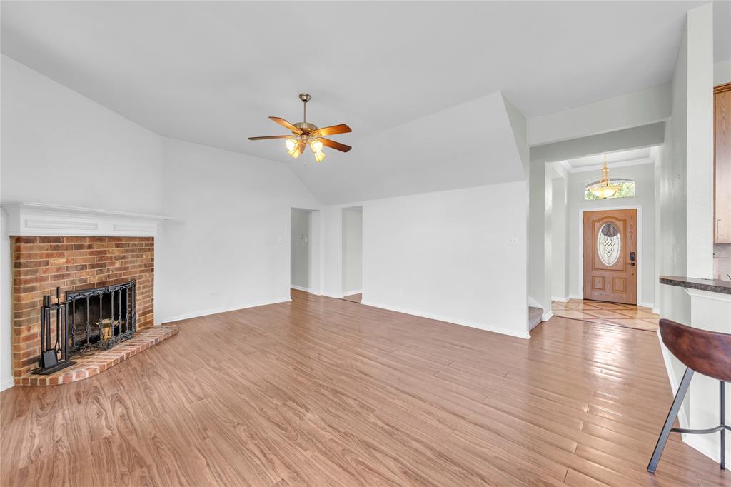 16055 Prairie Meadow Forney, TX 75126 - Photo 12 of 33 an empty room with wooden floor and fireplace