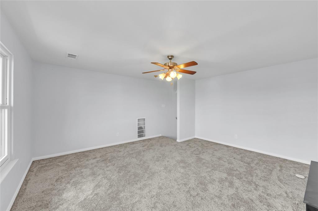 16055 Prairie Meadow Forney, TX 75126 - Photo 20 of 33 an empty room with a chandelier fan and windows