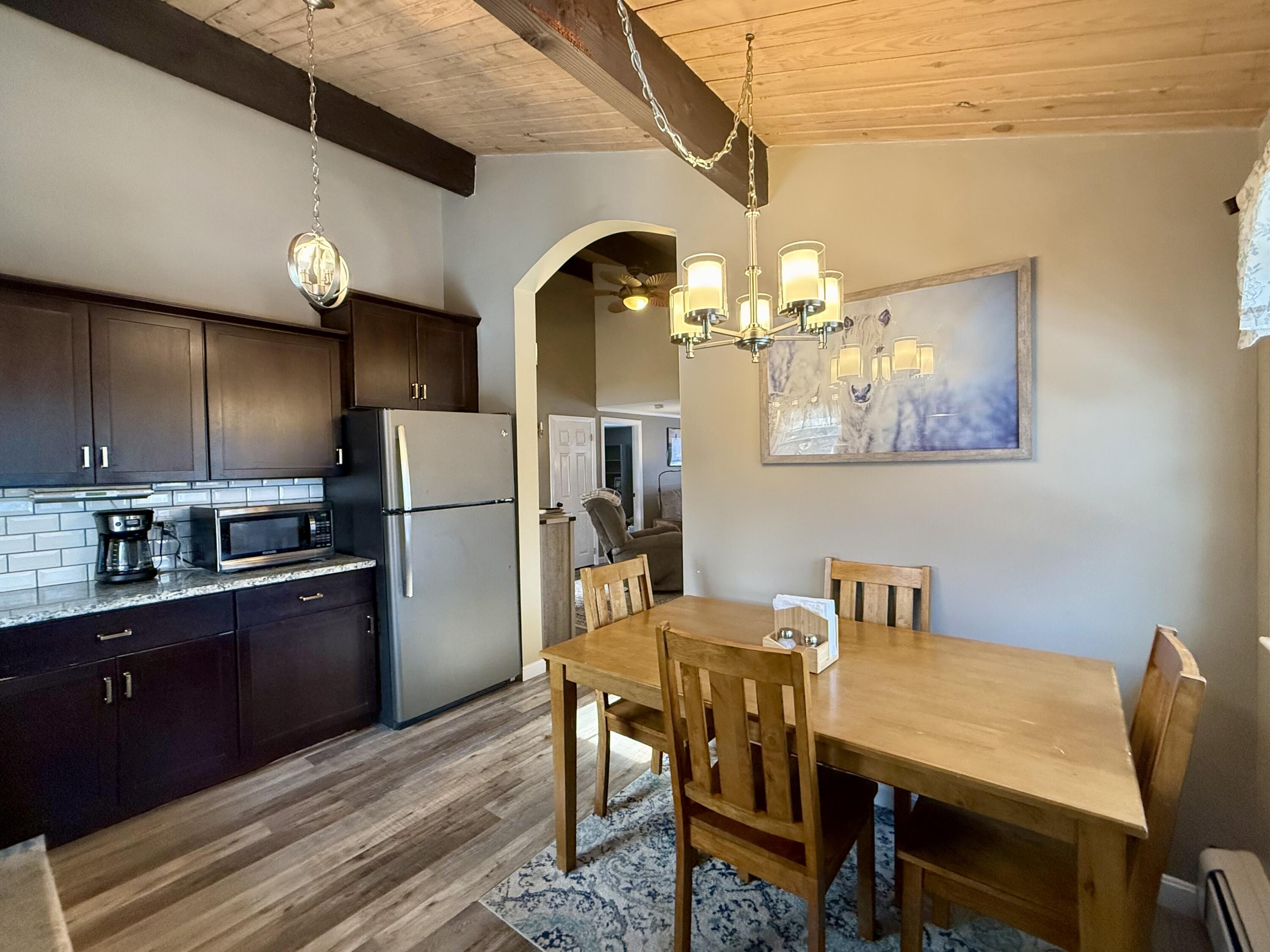 60 Ashumet Avenue Mashpee, MA 02649 - Photo 11 of 30 a kitchen with stainless steel appliances wooden floor dining table and chairs