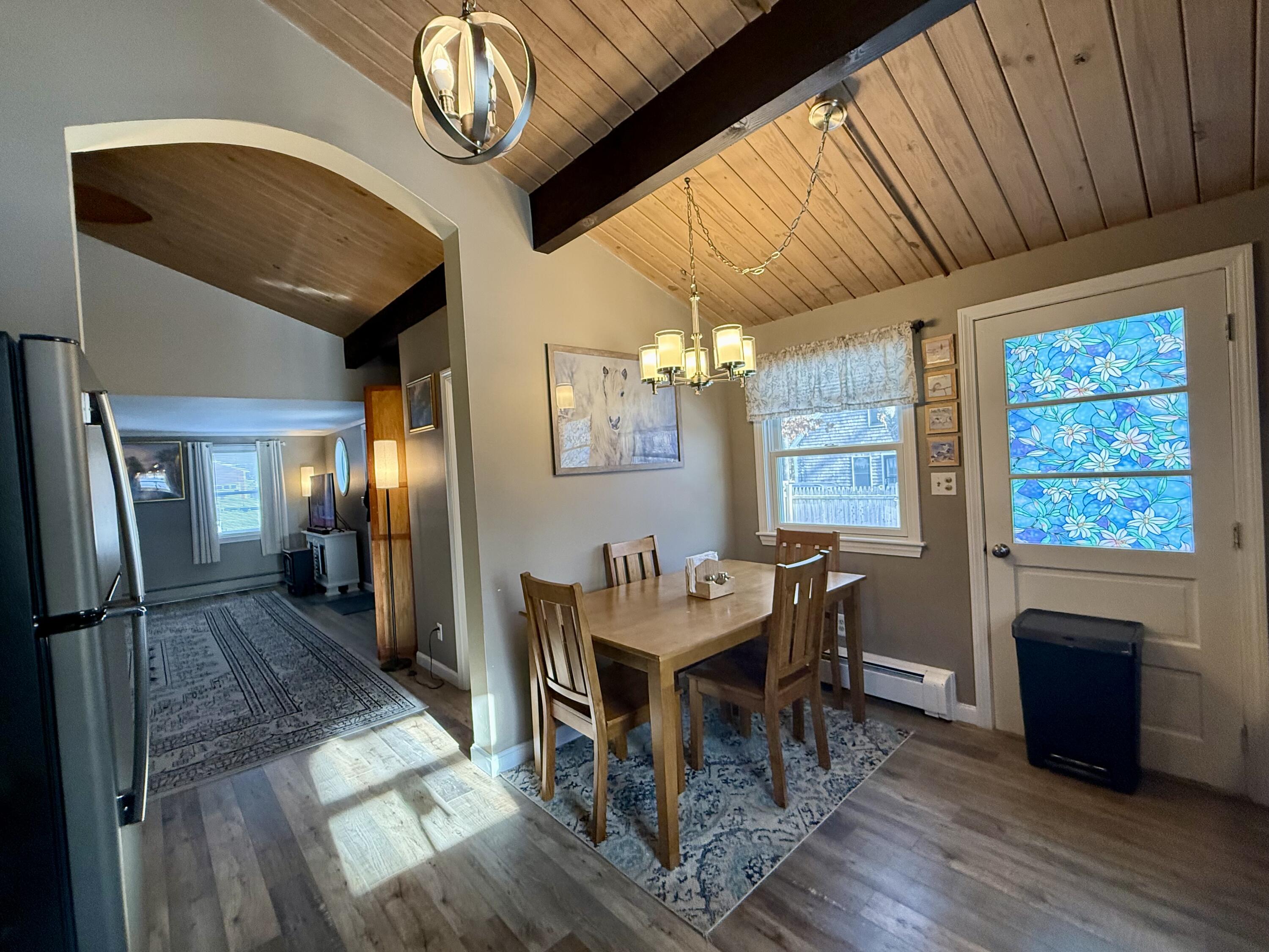 60 Ashumet Avenue Mashpee, MA 02649 - Photo 12 of 30 a dining room with furniture a rug a fireplace a chandelier and wooden floor