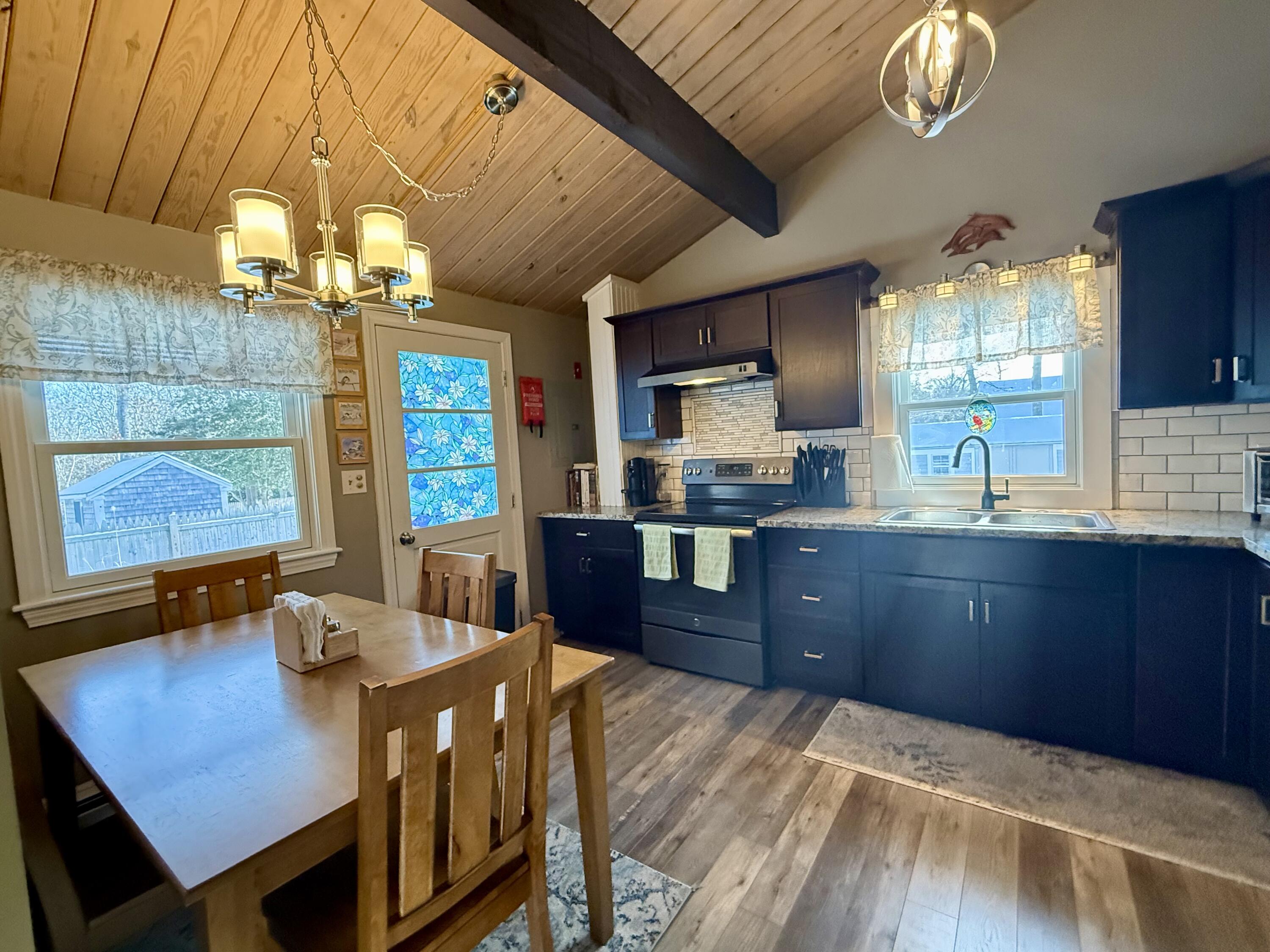 60 Ashumet Avenue Mashpee, MA 02649 - Photo 13 of 30 a kitchen with stainless steel appliances granite countertop a sink dishwasher a stove a refrigerator cabinets and dining table with wooden floor