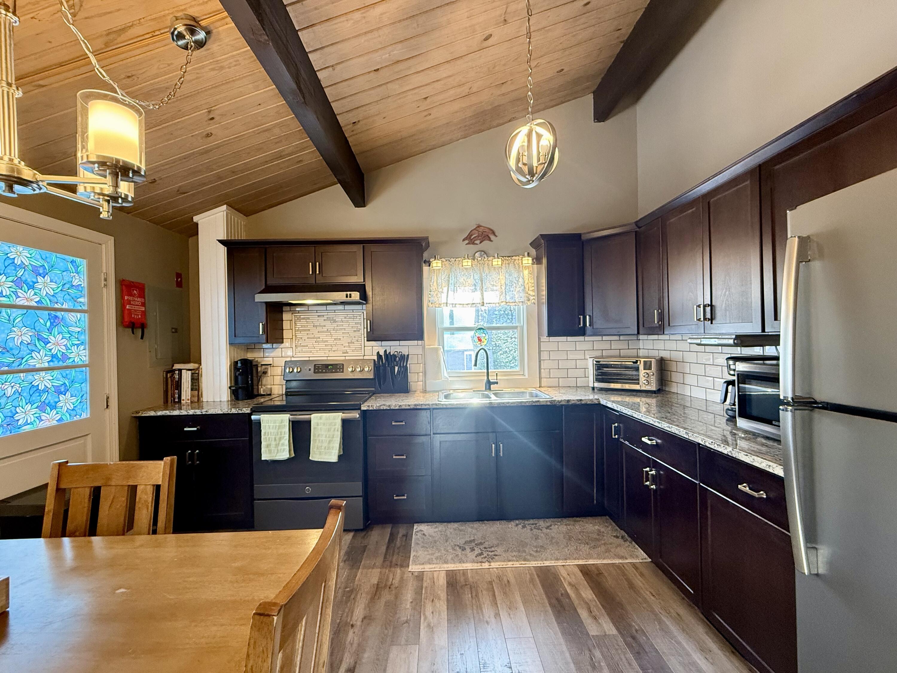 60 Ashumet Avenue Mashpee, MA 02649 - Photo 9 of 30 a large kitchen with stainless steel appliances wooden floors and wooden cabinets
