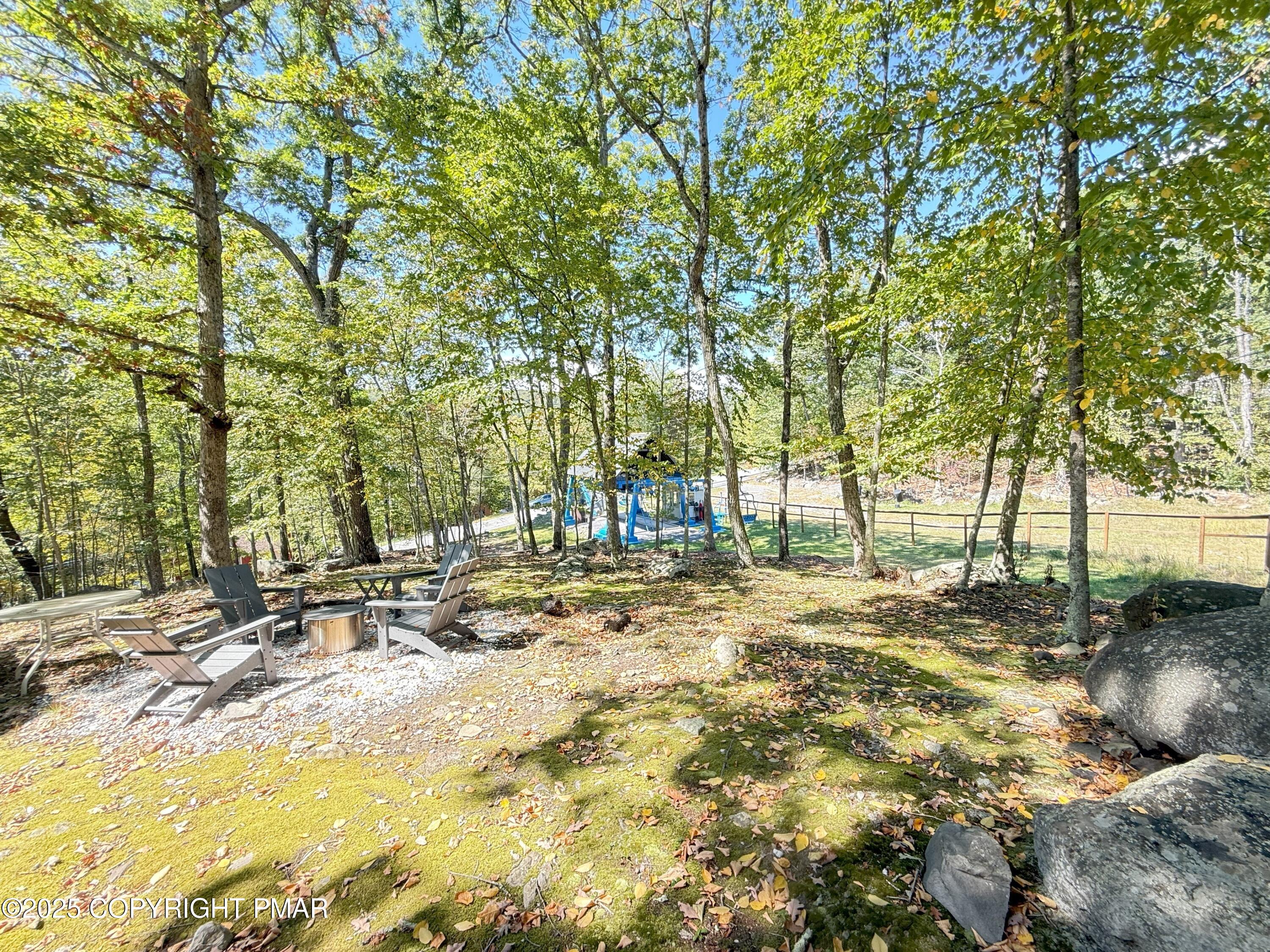 1026 Hampstead Road Bushkill, PA 18324 - Photo 37 of 61 a backyard of a house with table and chairs under a large tree