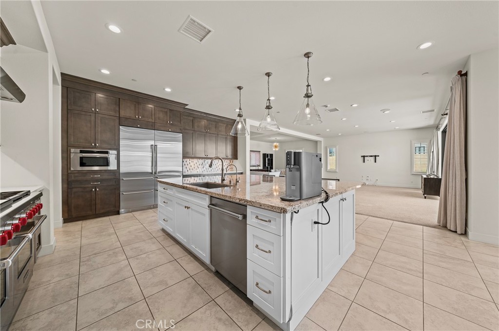 52 Eider Run Irvine, CA 92618 - Photo 31 of 46 a kitchen with stainless steel appliances kitchen island granite countertop a sink and cabinets
