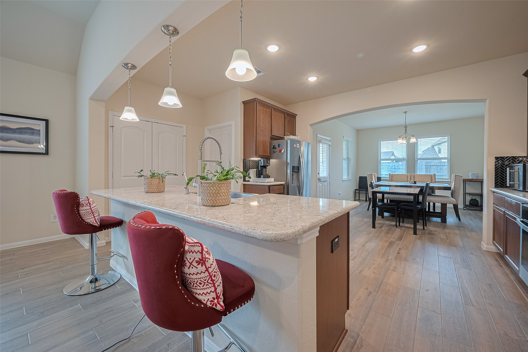5802 Ashland Lane Pasadena, TX 77505 - Photo 12 of 50 a kitchen with stainless steel appliances kitchen island granite countertop a dining table chairs and a refrigerator a sink with wooden floor