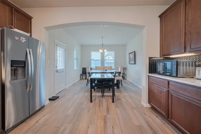 a kitchen with a table chairs refrigerator and cabinets