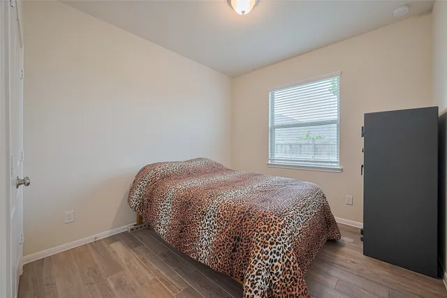 a bedroom with a bed and wooden floor