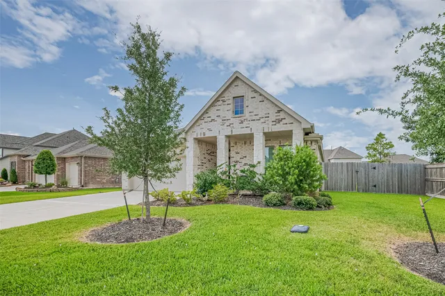 a front view of a house with a yard and tree s
