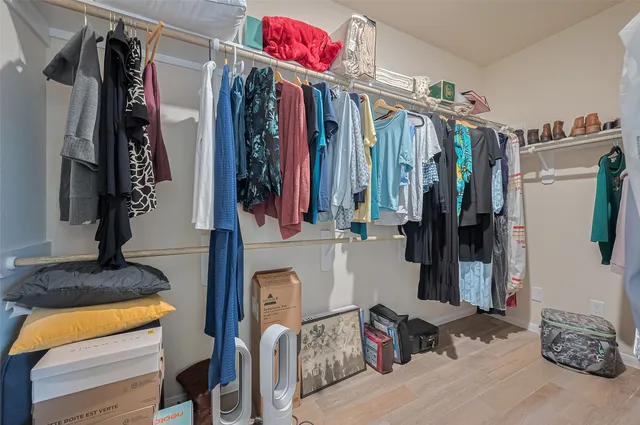 a view of walk in closet with clothes and shoes