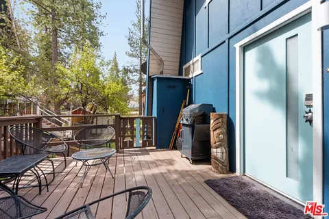 a view of a balcony with chairs and wooden floor