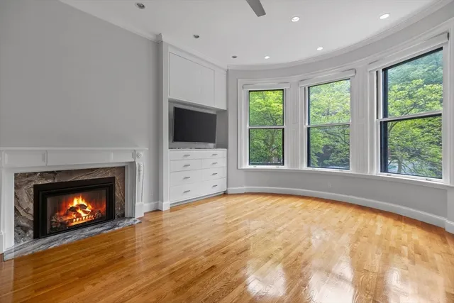 a view of an empty room with a fireplace and a window