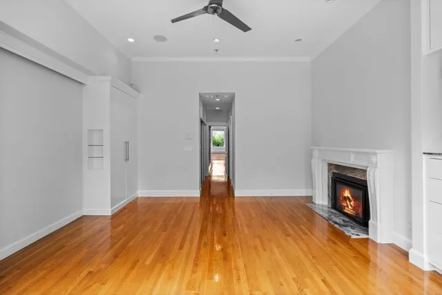 a view of empty room with wooden floor and fireplace