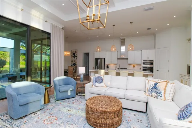 a living room with furniture kitchen view and a large window