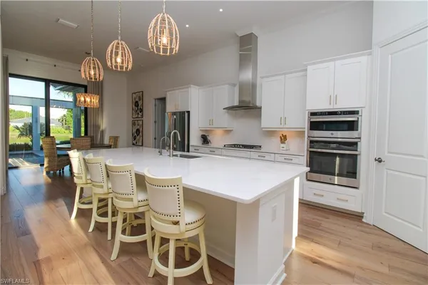 a kitchen with a dining table cabinets and stainless steel appliances
